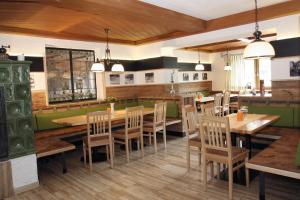 uma sala de jantar com mesas e cadeiras de madeira em Gasthof Hotel zur Post em Erlau