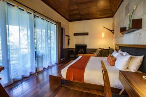 um quarto com uma cama e uma grande janela em Rodavento Boutique Hotel & Spa em Valle de Bravo