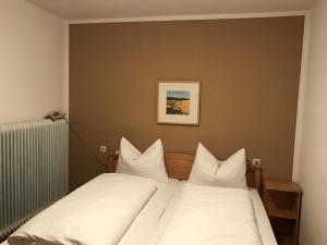 a bed with white sheets and pillows in a room at Gasthof Waldschenke in Bad Leonfelden