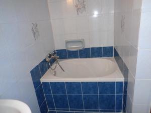 a bath tub in a bathroom with blue tiles at Loutra House Kythnos in Loutra +23 photos