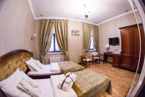 a hotel room with two beds and a mirror at Feder Boutique Hotel in Lviv