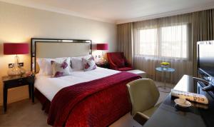 a bedroom with a large bed with a red blanket at The Bristol Hotel in Bristol