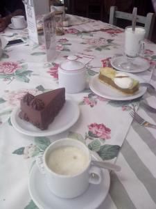een tafel met een bord cake en een kopje koffie bij Posada del Valle in Ushuaia