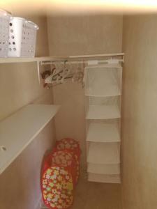 a small closet with white shelves and a stool at Marilyn Appartments in Kralendijk