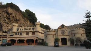 a castle building with cars parked in front of it at Hotel La Brasa in Vélez de Benaudalla