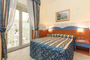 ein Hotelzimmer mit einem Bett und einem Balkon in der Unterkunft Hotel Borgo Del Mare in Civitavecchia