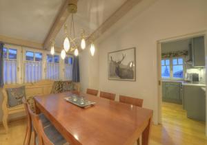 kuchnia i jadalnia z drewnianym stołem i krzesłami w obiekcie Chalet Anna Maria by Kaprun Rentals w Kaprunie
