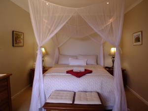 a bedroom with a bed with a canopy at Papillon Guest Suite in Simonʼs Town