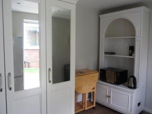 a kitchen with a white cabinet and a microwave at Studio in Stanmore