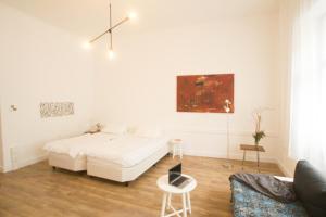 ein weißes Wohnzimmer mit einem Bett und einem Stuhl in der Unterkunft Central , 3 rooms in Frankfurter Tor in Berlin