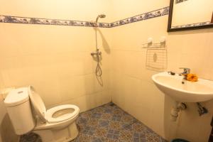 a bathroom with a toilet and a sink at Gusti Kaler House in Ubud