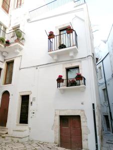 a white building with two windows and two balconies at Dimora Santa Maria in Putignano