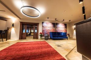 eine Lobby mit einem roten Teppich und einem blauen Sofa in der Unterkunft Alpenrose Kufstein in Kufstein