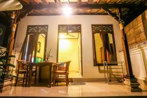 um quarto com uma mesa e cadeiras e um espelho em Gusti Kaler House em Ubud