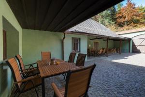 una mesa de madera y sillas en un patio en Hájenka Budislav, en Budislav