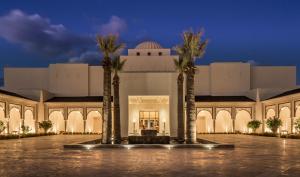 a building with palm trees in front of it at Four Seasons Hotel Tunis in Gammarth