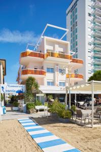a building on the beach with tables and chairs at Hotel Villa Gioiosa in Lido di Jesolo