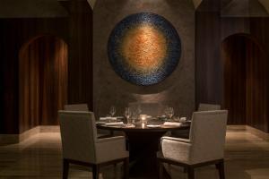 a dining room with a table with chairs and a vase at Four Seasons Hotel Tunis in Gammarth