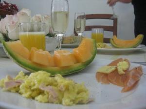 a table with a plate of food with fruit and drinks at B&B Cotacachi Hosteria Oro Azul in Cotacachi