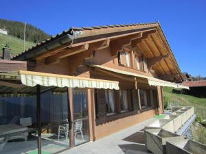 una grande casa in legno con un patio di fronte di Chalet Fernblick - Panoramic view a Beatenberg
