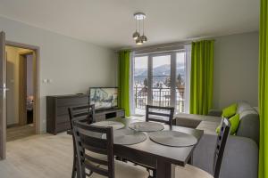 jadalnia ze stołem, krzesłami i kanapą w obiekcie Villa Mountain View Apartamenty w Szklarskiej Porębie