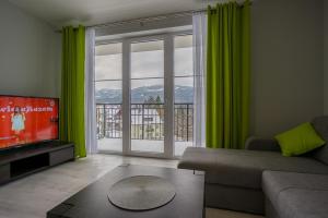 シュクラルスカ・ポレンバにあるVilla Mountain View Apartamentyのリビングルーム(ソファ、大きな窓付)