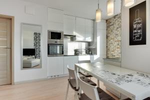 Una cocina y un comedor con mesa y sillas. en Aviator Modern 50, en Gdansk