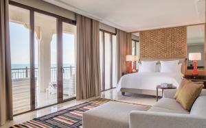 a bedroom with a bed and a balcony with the ocean at Four Seasons Hotel Tunis in Gammarth
