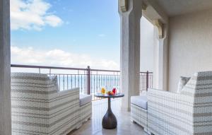 a balcony with two chairs and a table with a view at Four Seasons Hotel Tunis in Gammarth