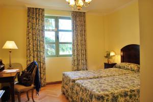 um quarto de hotel com uma cama e uma janela em La Quinta de los Cedros em Madri