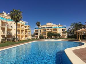 uma piscina em frente a dois edifícios de apartamentos em La Riviera - Serviden em Denia