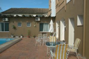 een patio met stoelen, een tafel en een zwembad bij Crigial Hotel in Jaguarão