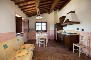 cocina y sala de estar con sofá y mesa en Terre Del Cantico Country House en Spello