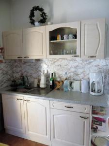 encimera de cocina con armarios blancos y fregadero en Haus Marta, en Smržovka