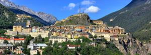 a town on top of a mountain with buildings at Hôtel Cristol in Briançon