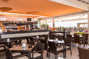 a restaurant with tables and chairs and a bar at Hotel Villa Gioiosa in Lido di Jesolo