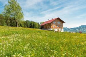 a house on a hill in a field of flowers at Alpenchalet Hageberg in Bolsterlang