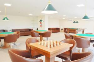 a room with tables and chairs and a chess board at Meridiano Hotel in Maceió