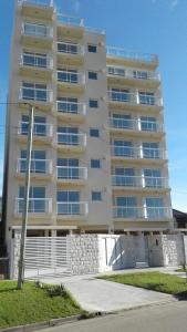 um edifício de apartamentos alto com um passeio em frente em 1-1/2 AMB c/BALCON SOLEADO en EDIFICIO FRENTE AL MAR em Mar del Plata