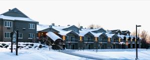 Hotel Bromont في بورمونت: صف من البيوت والثلج على السطوح