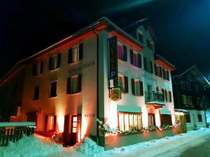 a building is lit up in the snow at night at Hotel Dalla Posta Platta in Pardè