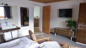a bedroom with a bed and a sink and a tv at Haus Rosi in Uttendorf