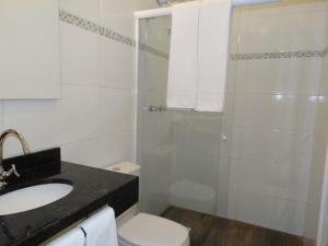 a bathroom with a shower and a toilet and a sink at Pousada Natália in Torres