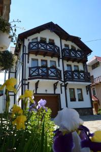 un edificio con flores delante en Fachwerk, en Yaremche