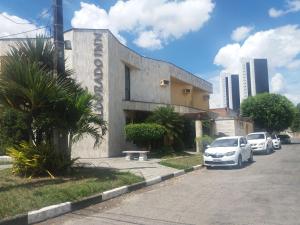 a building with cars parked on the side of a street at Hotel Eldorado Inn in Feira de Santana