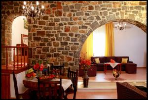 a living room with a stone wall and a table and chairs at Creta guesthouse ARXONTIKO! in Smárion