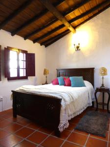 1 dormitorio con 1 cama grande y almohadas coloridas en Monte do Laranjal, en Monsaraz