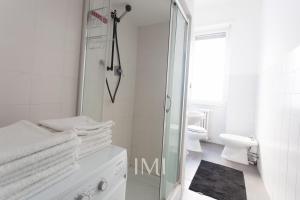 ミラノにあるMilan Center Apartmentの白いバスルーム(シャワー、トイレ付)