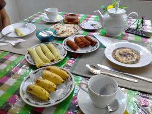 una mesa con platos de comida y tazas de café en Liyara Home Stay, en Sigiriya