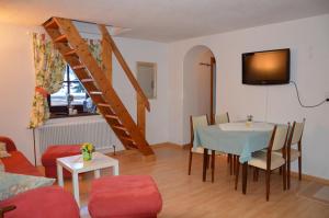 a living room with a table and a staircase at Alte Schmiede in Bad Gastein